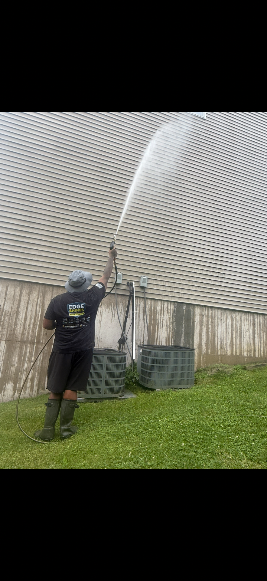 Edge Shines technician pressure washing a Hudson Valley home exterior